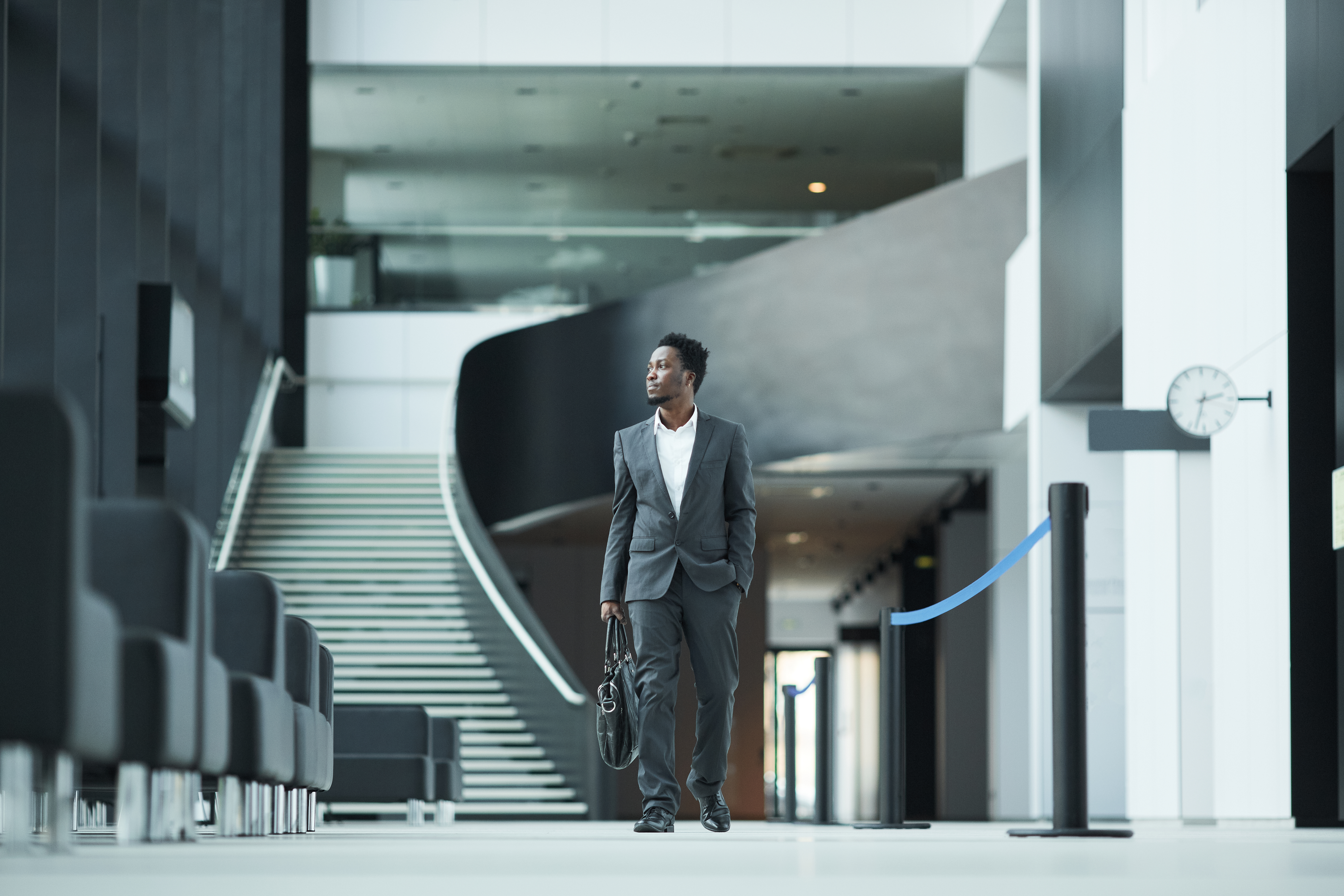 A professional walking through a modern atrium — the start of a working relationship.